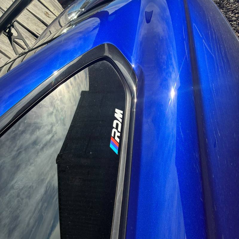 RDM window sticker on the rear quarter window of a blue M4
