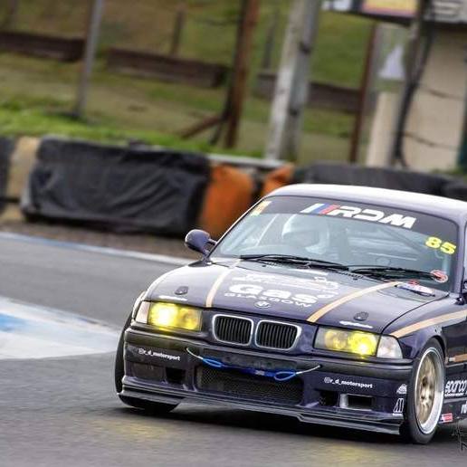 The RDM E36 race car on track, with the RDM sun strip