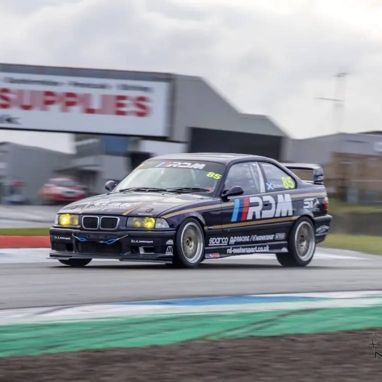 The RDM E36 race car through a corner, sun strip on the screen