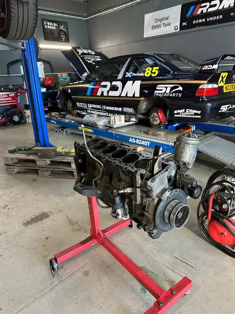 Car 85 on the lift with its engine stripped to a bare block on a stand