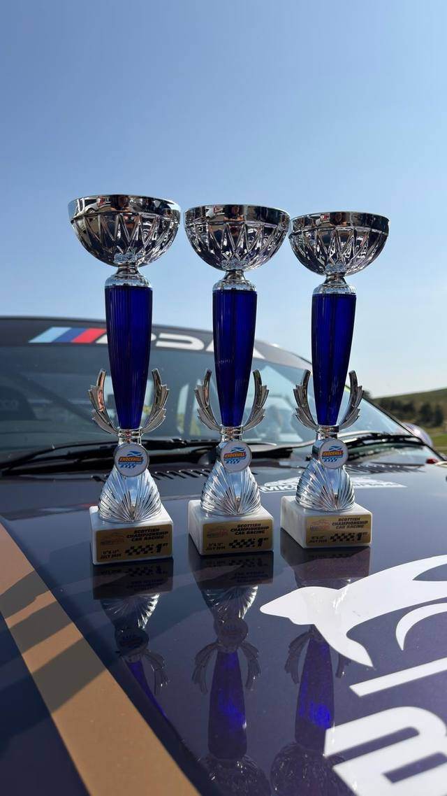 Three 1st place trophies from Knockhill lined up on the bonnet of car 85