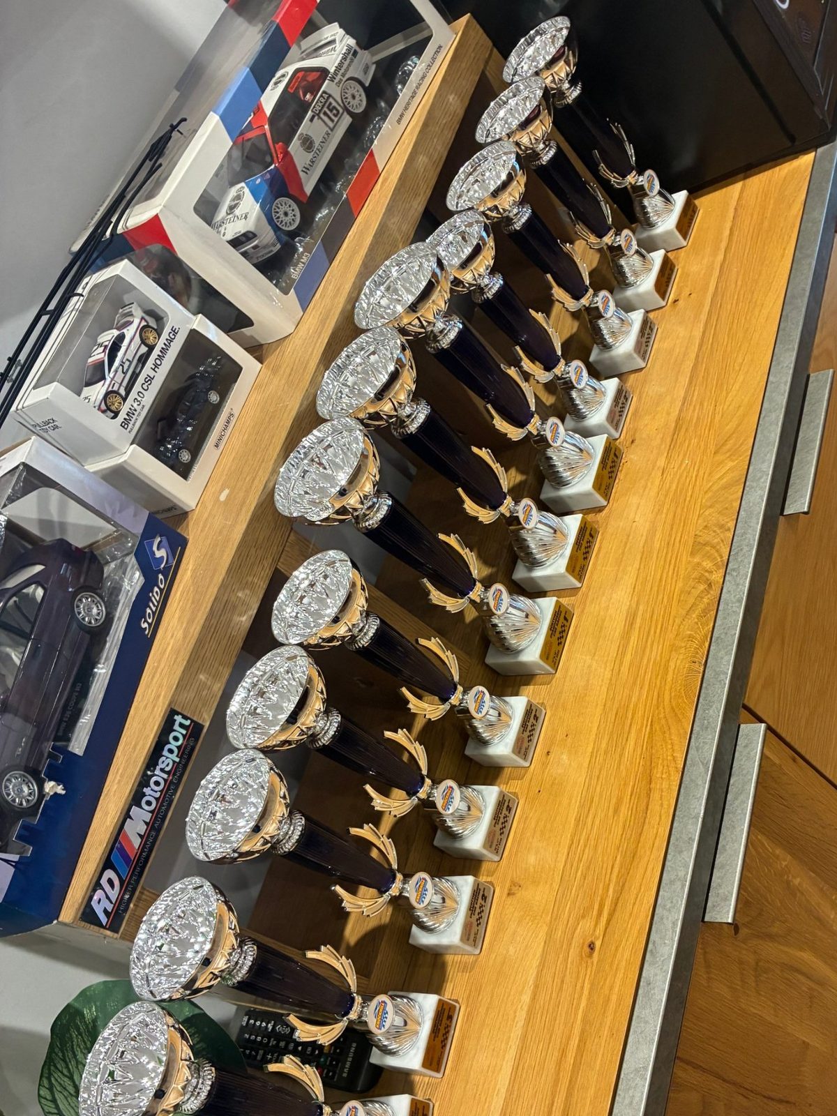 A row of RDM's racing trophies on a shelf in the workshop